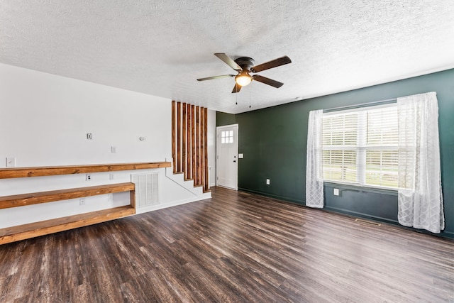 empty room with a textured ceiling, ceiling fan, and dark wood-type flooring