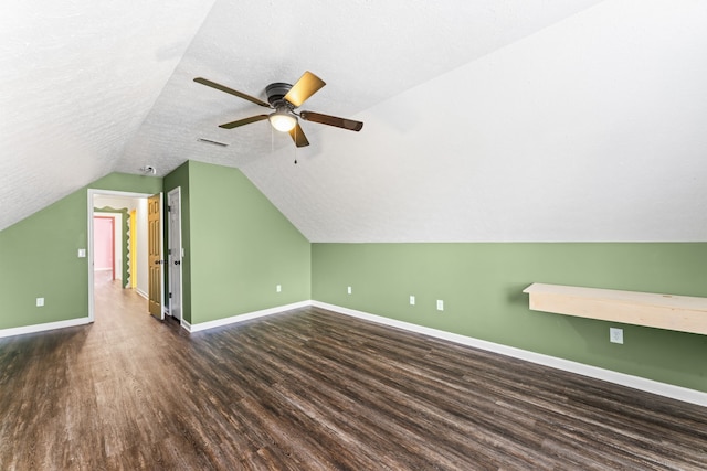 additional living space featuring a textured ceiling, ceiling fan, dark hardwood / wood-style flooring, and lofted ceiling