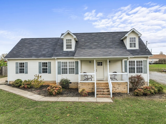 cape cod home featuring a front lawn and covered porch