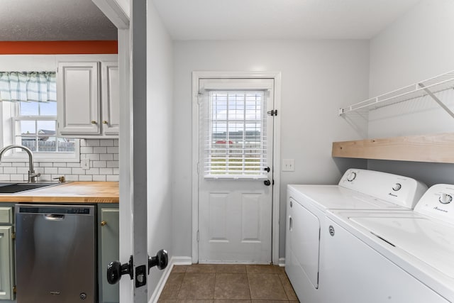 clothes washing area with tile patterned flooring, independent washer and dryer, a textured ceiling, and sink