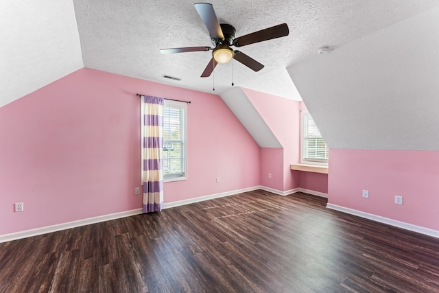 bonus room featuring dark hardwood / wood-style floors, plenty of natural light, lofted ceiling, and a textured ceiling