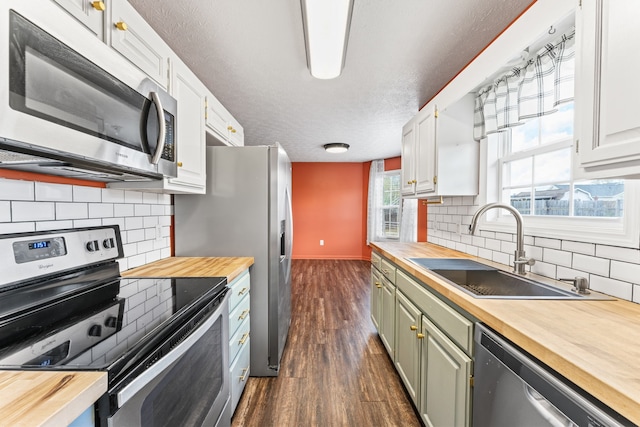 kitchen featuring dark hardwood / wood-style floors, white cabinetry, butcher block counters, and stainless steel appliances