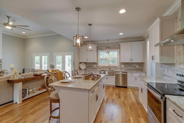 11B Double Br, Columbia, TN 38401 - kitchen with stainless steel appliances, wall chimney exhaust hood, a sink, open floor plan, and white cabinets