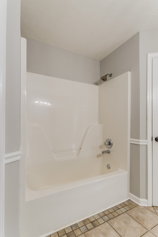 bathroom featuring tile patterned floors, shower / bathing tub combination, and a textured ceiling