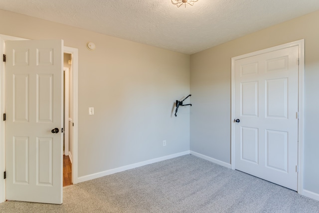 carpeted spare room with a textured ceiling