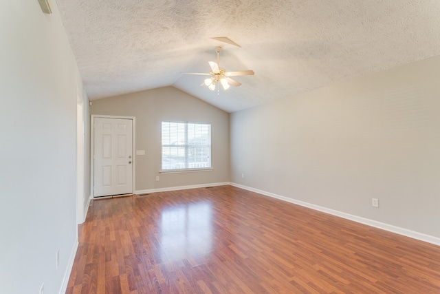 spare room featuring hardwood / wood-style floors, a textured ceiling, ceiling fan, and lofted ceiling