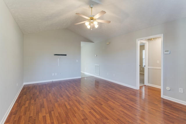 unfurnished room featuring a textured ceiling, ceiling fan, dark wood-type flooring, and vaulted ceiling