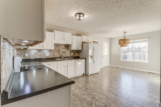 kitchen featuring decorative backsplash, white appliances, sink, decorative light fixtures, and white cabinetry