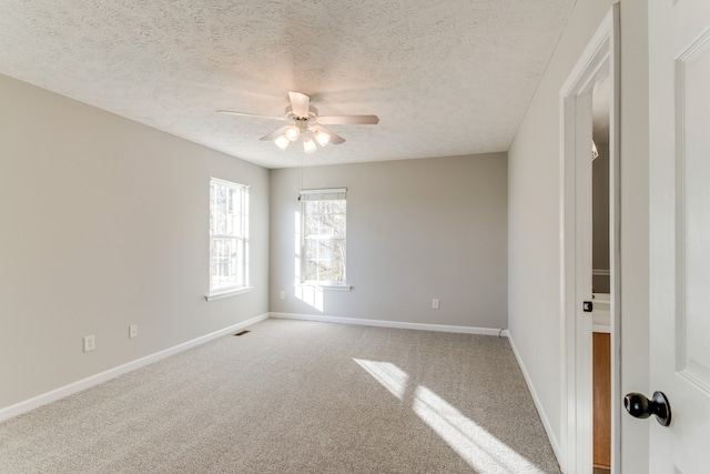 spare room featuring ceiling fan, carpet, and a textured ceiling