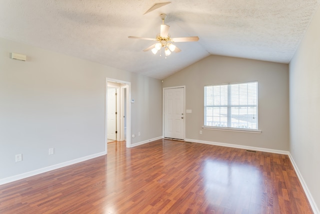 unfurnished room featuring dark hardwood / wood-style floors, ceiling fan, a textured ceiling, and vaulted ceiling