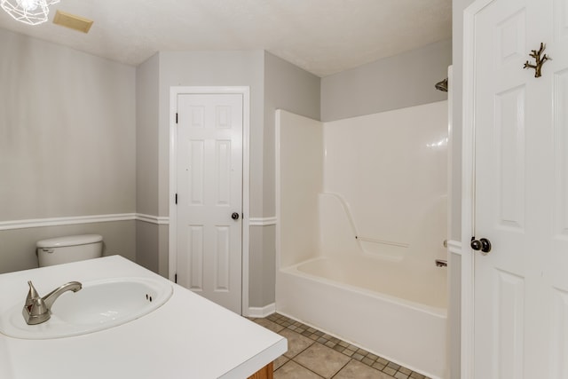 full bathroom with shower / bath combination, tile patterned floors, vanity, a textured ceiling, and toilet