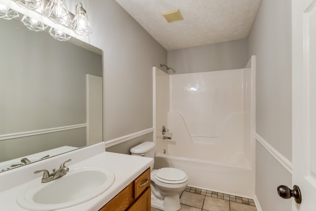 full bathroom featuring vanity, bathtub / shower combination, tile patterned floors, toilet, and a textured ceiling