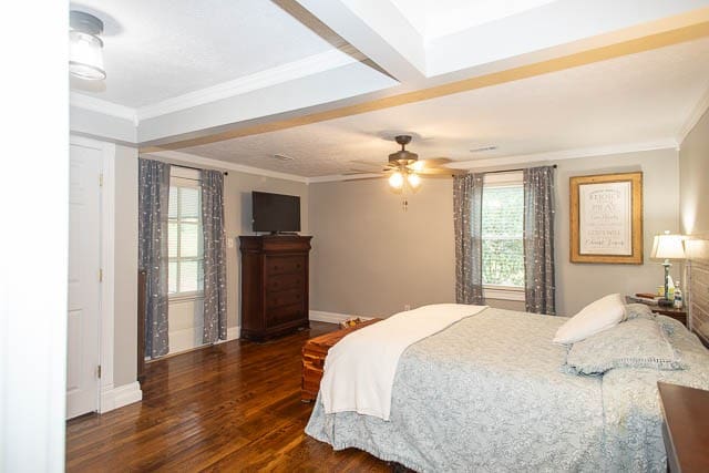 bedroom with ceiling fan, dark hardwood / wood-style flooring, ornamental molding, and multiple windows