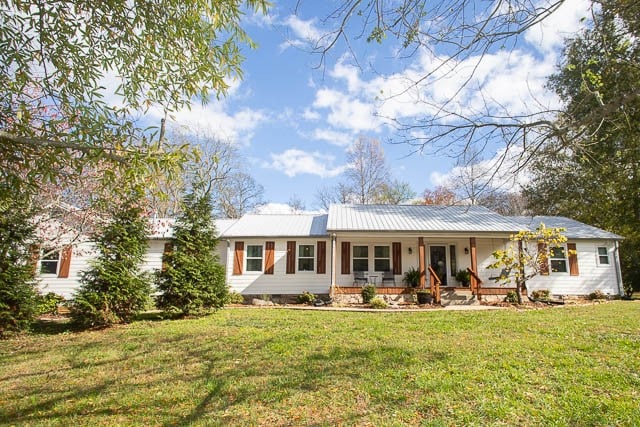 single story home with a porch and a front yard