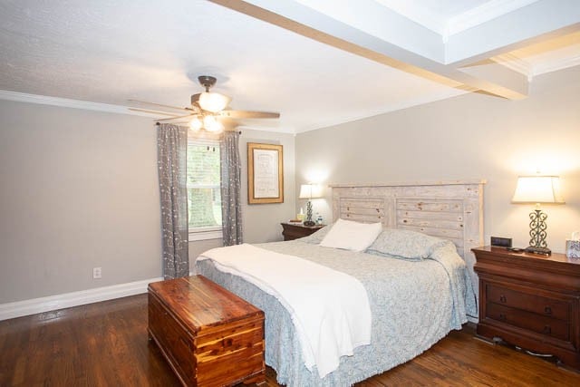 bedroom featuring ceiling fan, dark hardwood / wood-style flooring, beamed ceiling, and ornamental molding