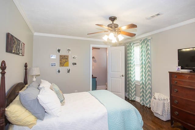 bedroom featuring dark hardwood / wood-style flooring, ceiling fan, and ornamental molding