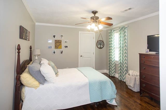 bedroom featuring ceiling fan, crown molding, and dark wood-type flooring