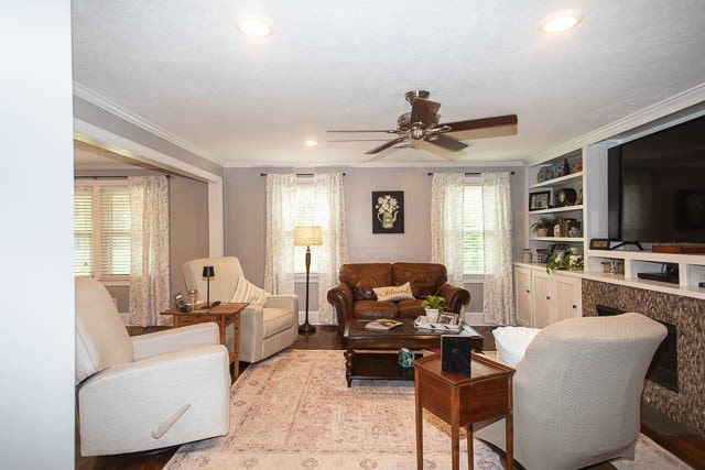 living room with ceiling fan, light hardwood / wood-style flooring, and ornamental molding