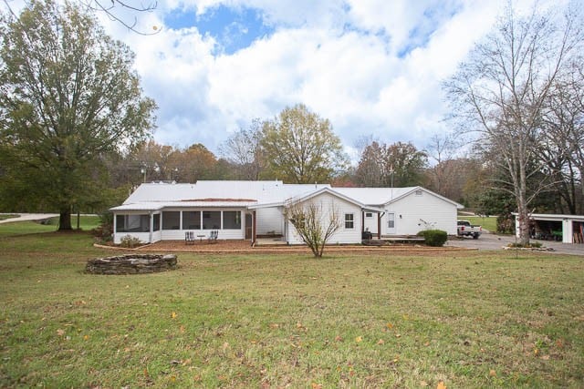 view of front of property with a front lawn and a sunroom