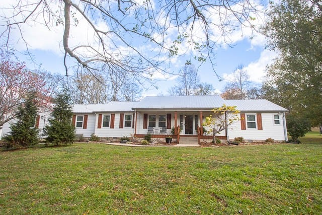 ranch-style home with a front lawn and a porch