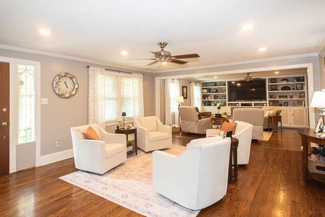 living room with dark hardwood / wood-style floors, ceiling fan, and ornamental molding