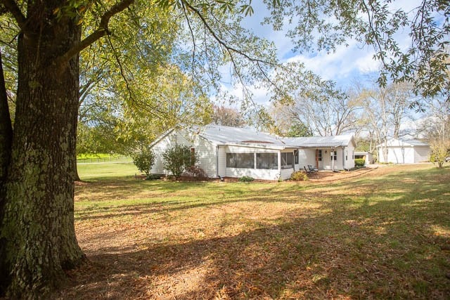 rear view of house featuring a lawn