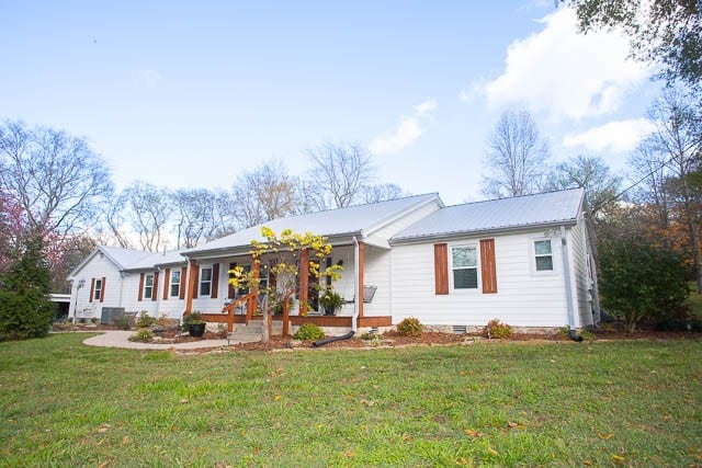 ranch-style house featuring a porch and a front lawn