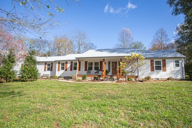 ranch-style home with covered porch and a front yard