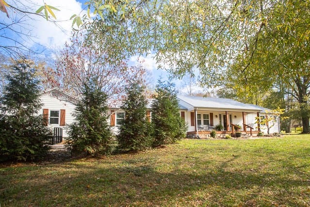 rear view of house with a lawn and covered porch