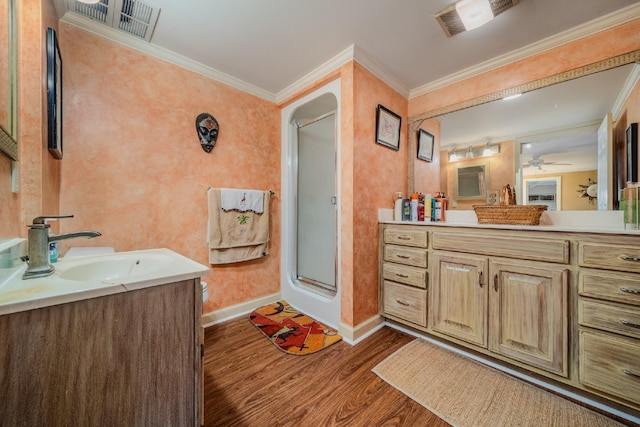 bathroom featuring vanity, crown molding, wood-type flooring, and a shower with door