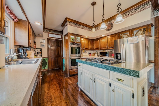 kitchen with stainless steel appliances, sink, pendant lighting, a center island, and dark hardwood / wood-style floors