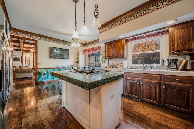 kitchen with a center island, dark hardwood / wood-style flooring, ornamental molding, and appliances with stainless steel finishes