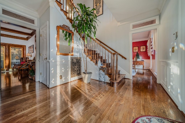 foyer featuring wood-type flooring and ornamental molding