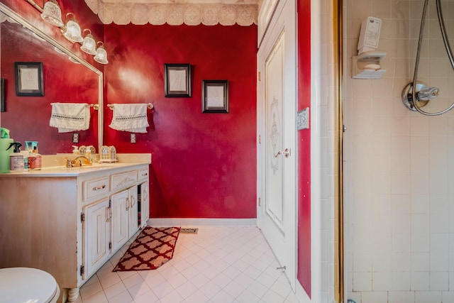 bathroom featuring tile patterned flooring, vanity, toilet, and walk in shower