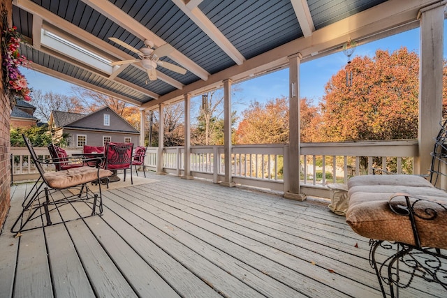 sunroom with vaulted ceiling with beams and ceiling fan