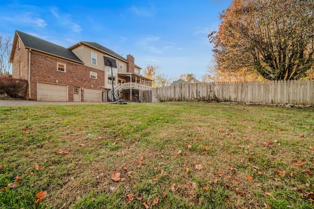 view of yard with a garage and a wooden deck