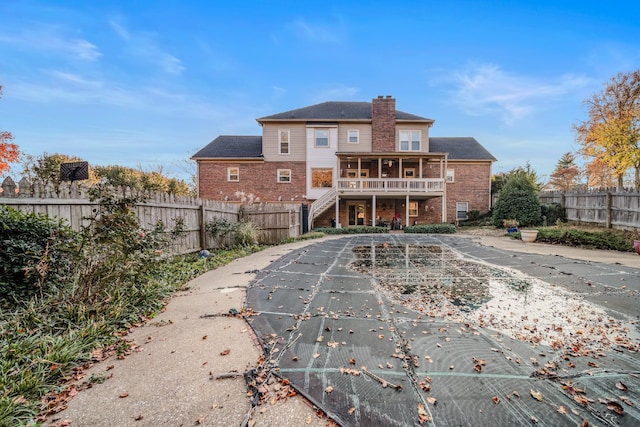 back of house with a covered pool