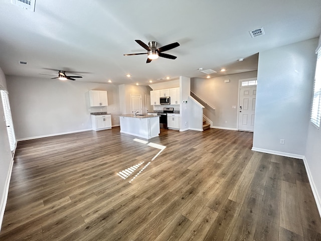 unfurnished living room featuring dark hardwood / wood-style floors and ceiling fan