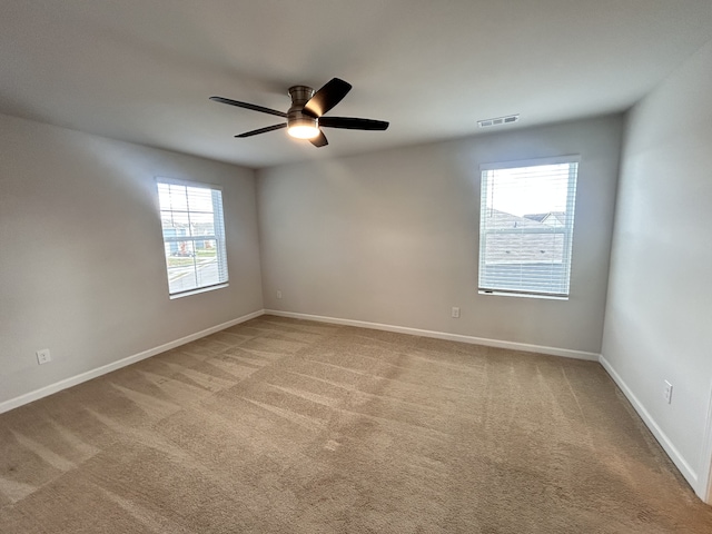 carpeted spare room with plenty of natural light and ceiling fan