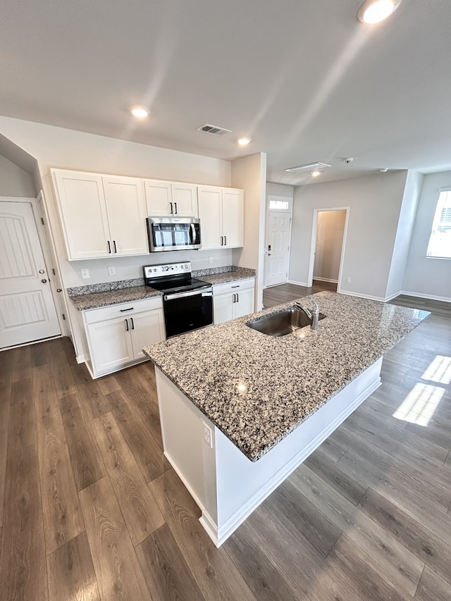 kitchen featuring a kitchen island with sink, white cabinets, and stainless steel appliances