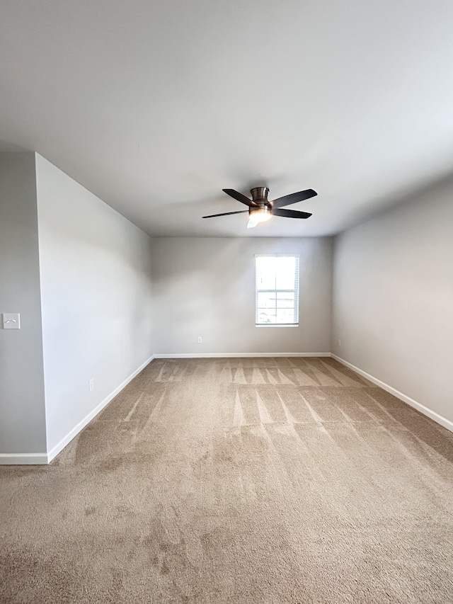 unfurnished room featuring ceiling fan and carpet