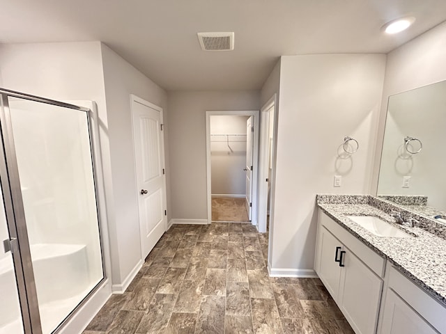 bathroom featuring vanity, an enclosed shower, and wood-type flooring