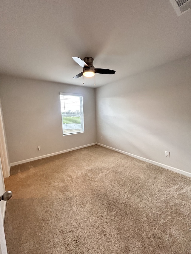 carpeted spare room featuring ceiling fan