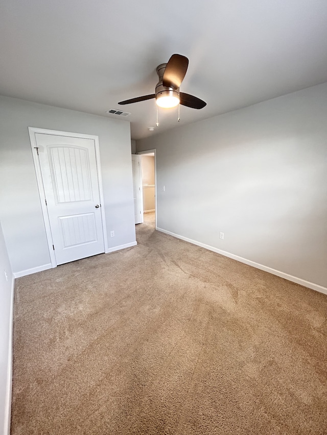 unfurnished bedroom with ceiling fan, a closet, and carpet