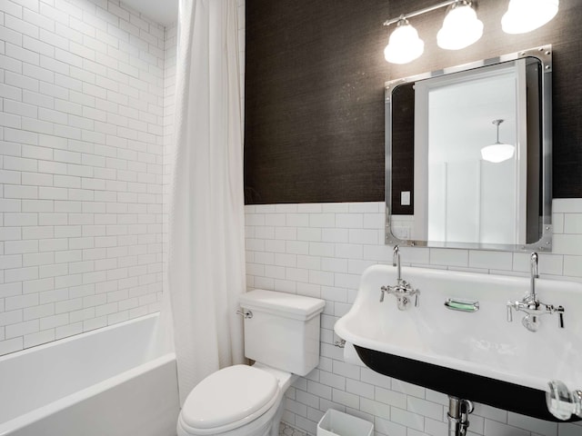 full bathroom with sink, shower / bath combination with curtain, toilet, and tile walls