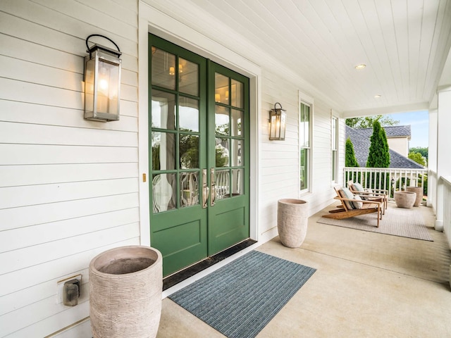 view of exterior entry featuring a porch and french doors