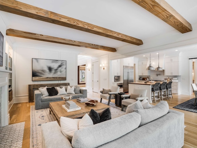 living room with beamed ceiling and light hardwood / wood-style flooring