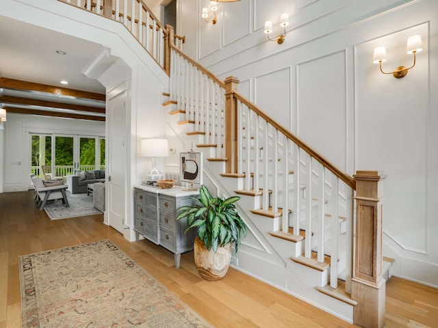 staircase featuring beam ceiling and wood-type flooring