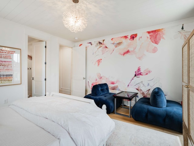 bedroom with a notable chandelier and light wood-type flooring