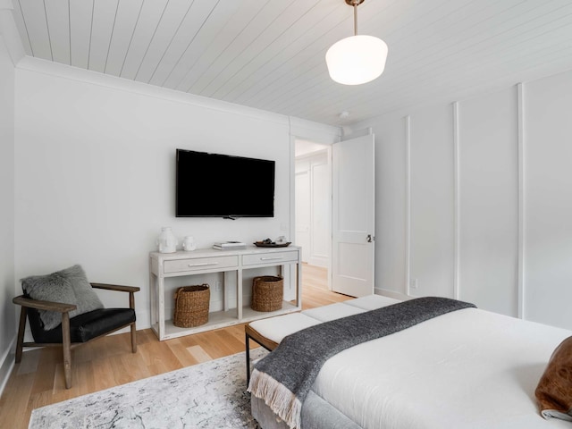 bedroom with crown molding, light hardwood / wood-style flooring, and wood ceiling